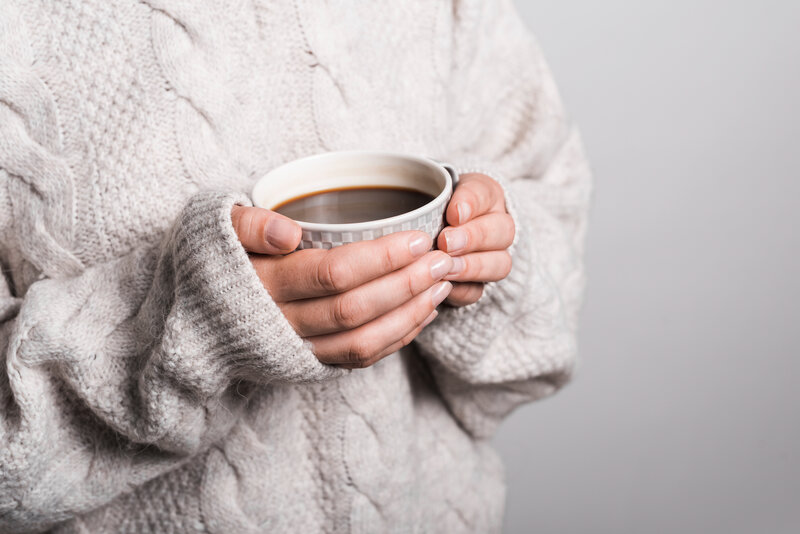 mid-section-woman-woolen-clothes-holding-coffee-cup